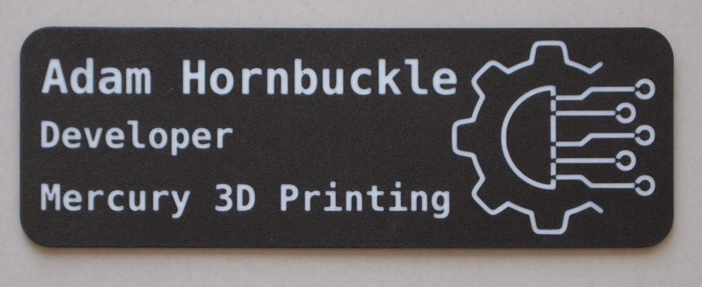 Name tag with 'Adam Hornbuckle' and 'Developer' text, featuring a gear icon, on a black background.